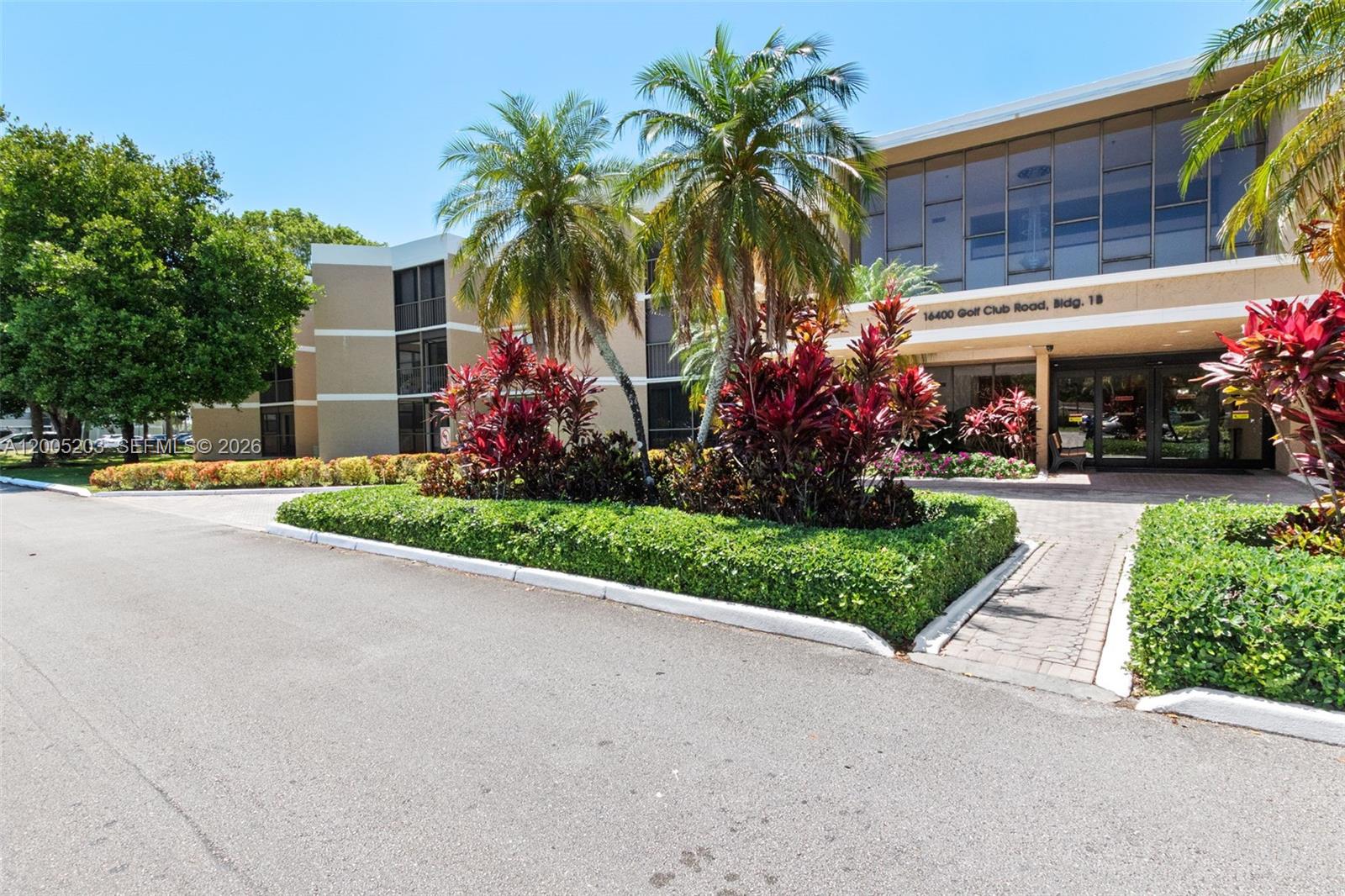 16400 Golf Club Road, Unit 104 Weston, FL 33326 - Photo 1 of 34 a front view of house with small garden and palm trees