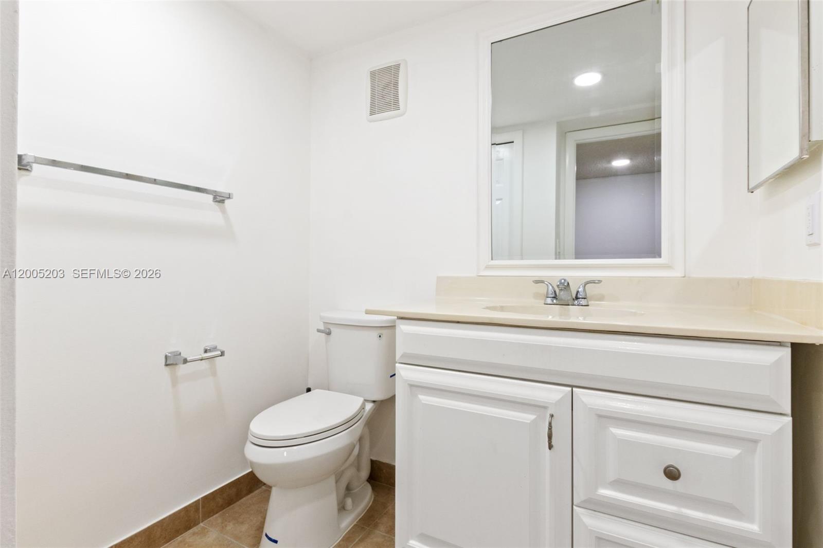 16400 Golf Club Road, Unit 104 Weston, FL 33326 - Photo 11 of 34 a bathroom with a toilet sink vanity and mirror