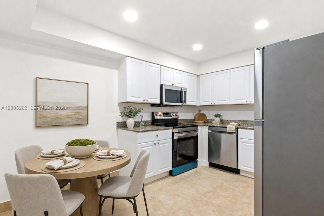 16400 Golf Club Road, Unit 104 Weston, FL 33326 - Photo 14 of 34 a kitchen with stainless steel appliances granite countertop a refrigerator a stove a sink a dining table and chairs