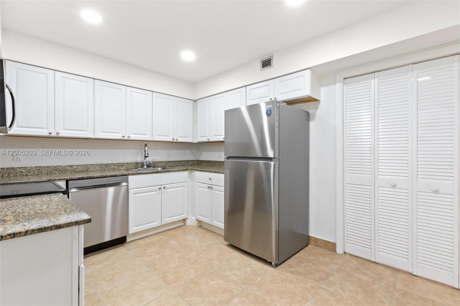 16400 Golf Club Road, Unit 104 Weston, FL 33326 - Photo 16 of 34 a kitchen with stainless steel appliances granite countertop a refrigerator and a stove