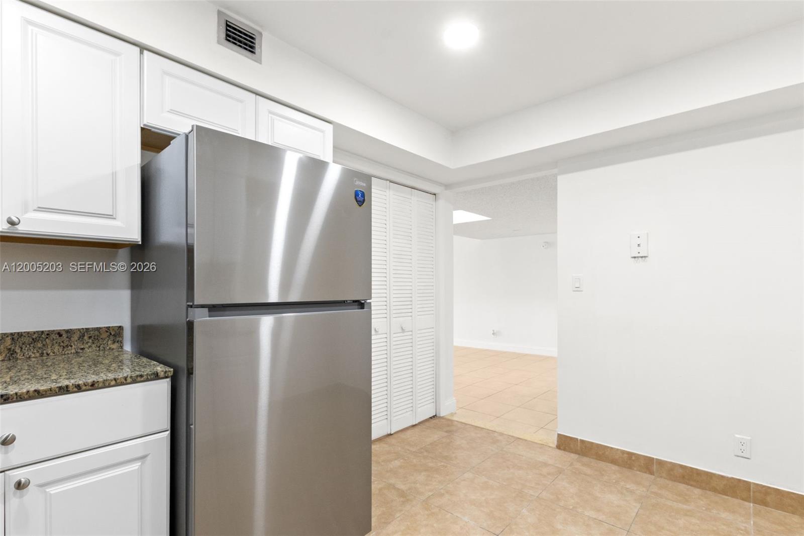 16400 Golf Club Road, Unit 104 Weston, FL 33326 - Photo 17 of 34 a view of a refrigerator in kitchen and white cabinets