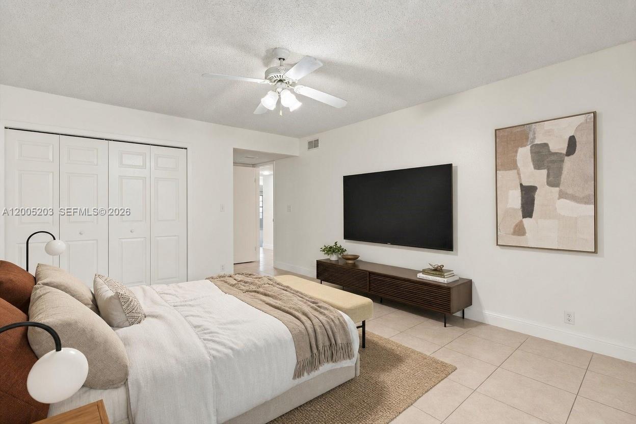 16400 Golf Club Road, Unit 104 Weston, FL 33326 - Photo 21 of 34 a bedroom with bed and tv