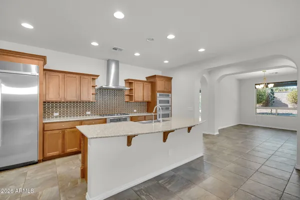 a kitchen with stainless steel appliances granite countertop a sink and a refrigerator