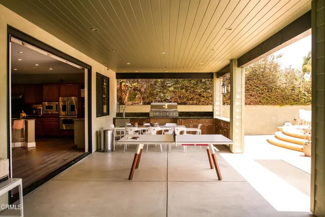 a living room with stainless steel appliances dining table and chairs