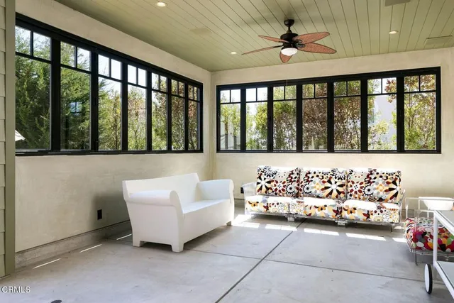 a living room with furniture a flat screen tv and a window