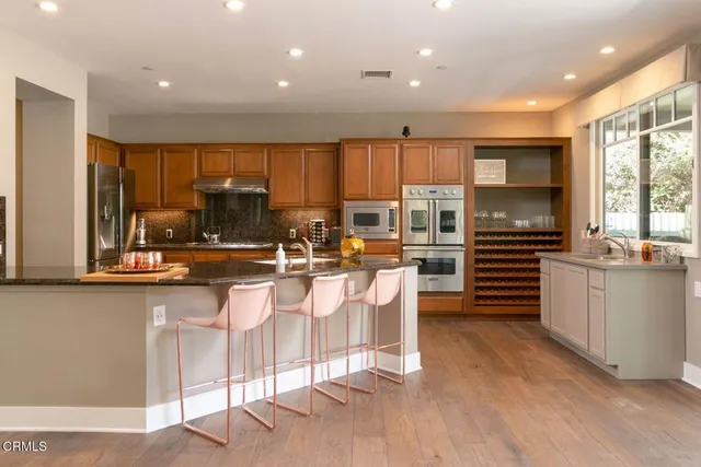 a kitchen with stainless steel appliances granite countertop a refrigerator and a sink