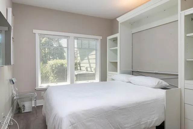 a bedroom with a bed and a large window