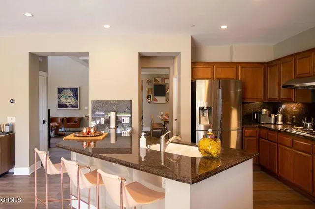 a kitchen with stainless steel appliances granite countertop a refrigerator a stove and a sink