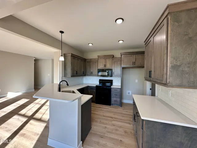 a kitchen with stainless steel appliances kitchen island granite countertop a sink refrigerator and cabinets