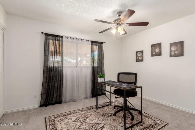 a view of a workspace with furniture and a window
