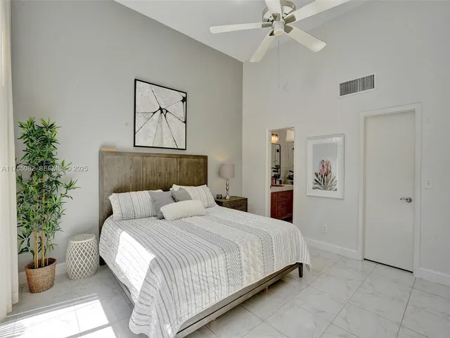a bedroom with a large bed and a potted plant
