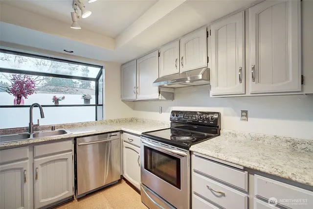 a kitchen with granite countertop white cabinets and white appliances
