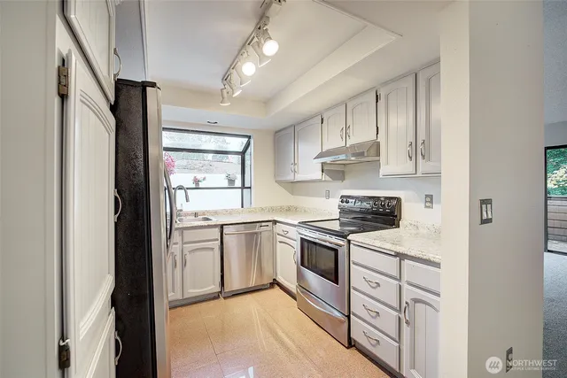 a kitchen with white cabinets and white appliances