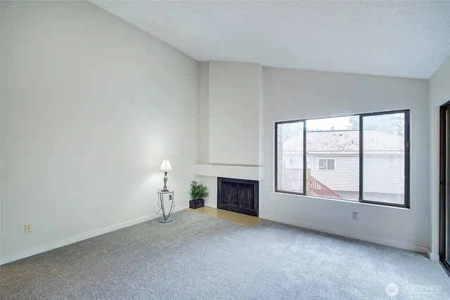 an empty room with fireplace and windows