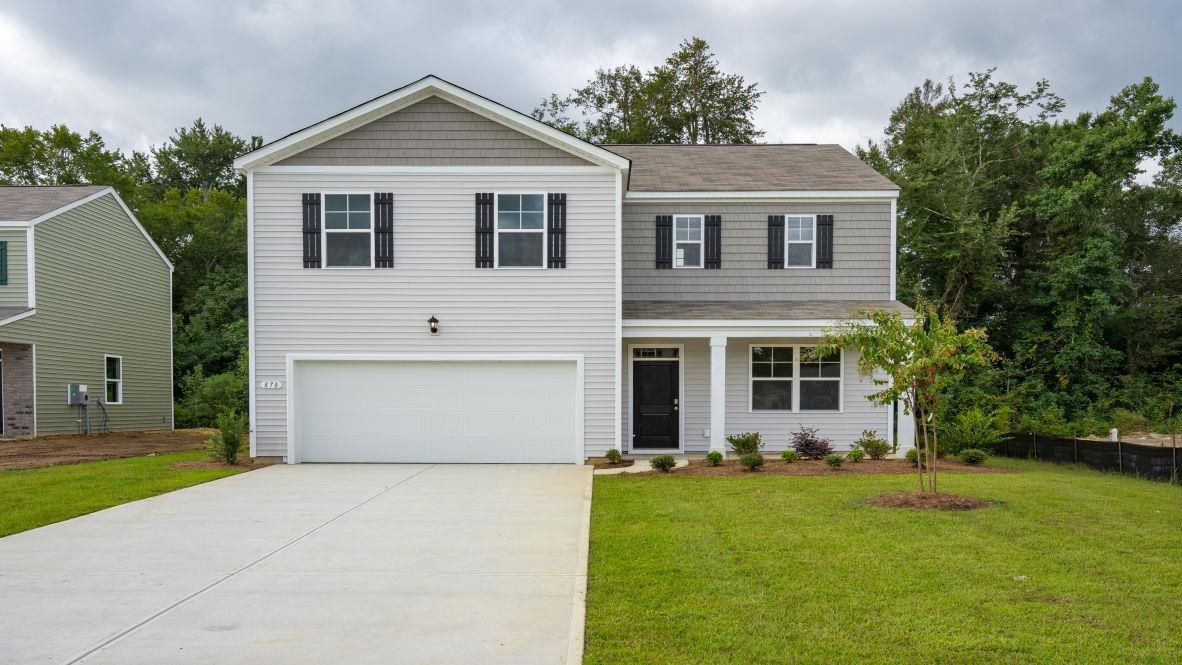 View of front of property with concrete driveway, covered porch, roof with shingles, and a garage