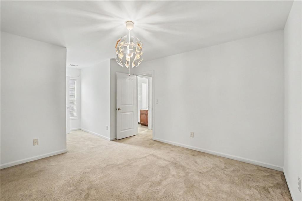 566 Olympic Way Acworth, GA 30102 - Photo 21 of 38 an empty room with a chandelier fan and wooden floor