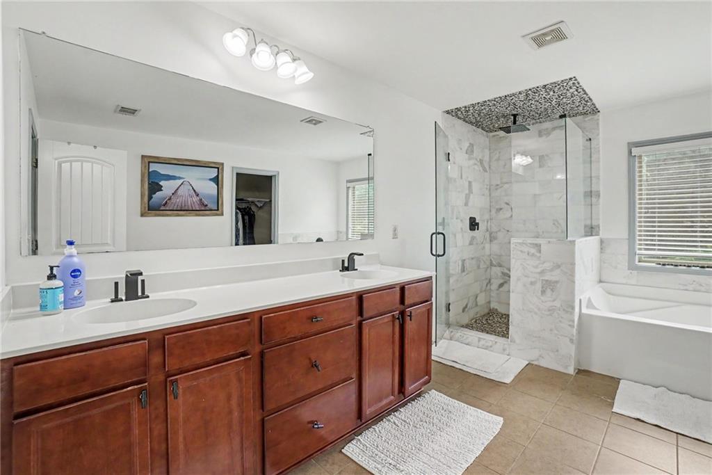 566 Olympic Way Acworth, GA 30102 - Photo 35 of 38 a spacious bathroom with double vanity a a double vanity sink a large mirror a shower and a bathtub