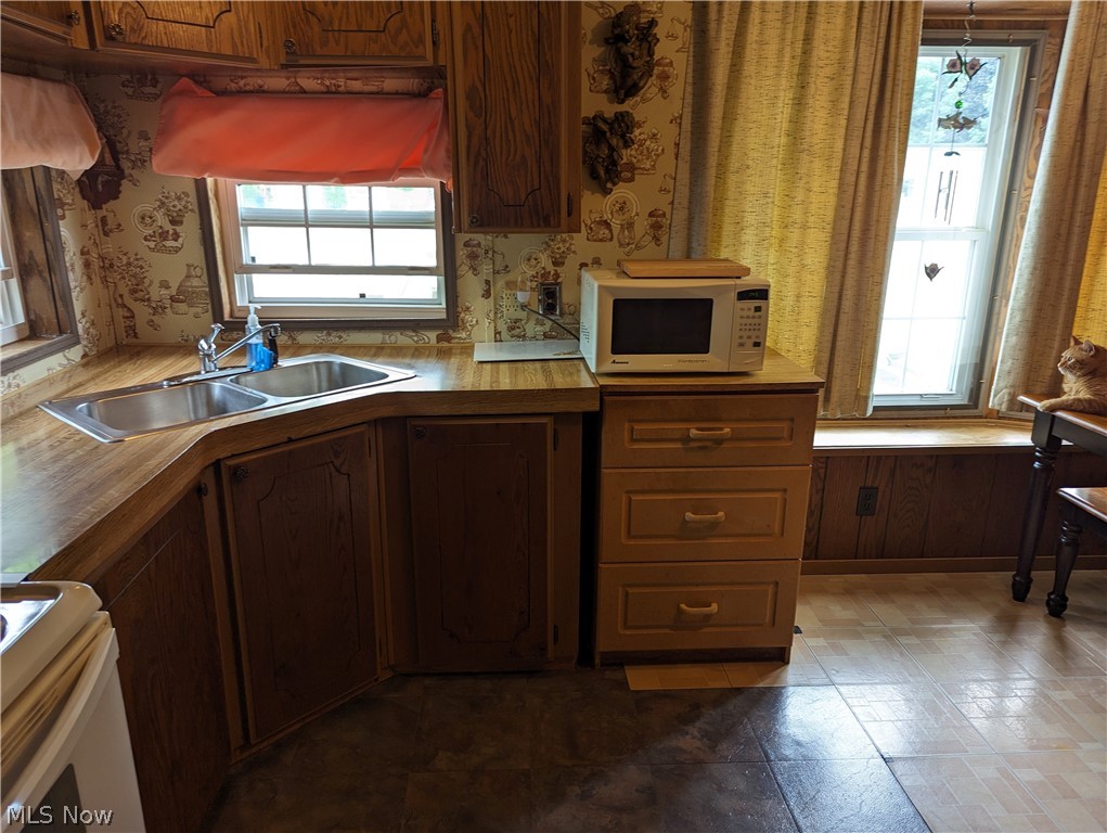 35157 Center Ridge Road, Unit 112 North Ridgeville, OH 44039 - Photo 5 of 9 Kitchen with white appliances, sink, plenty of natural light, and tile floors