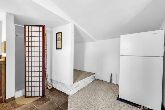 a walk in closet with wooden floor