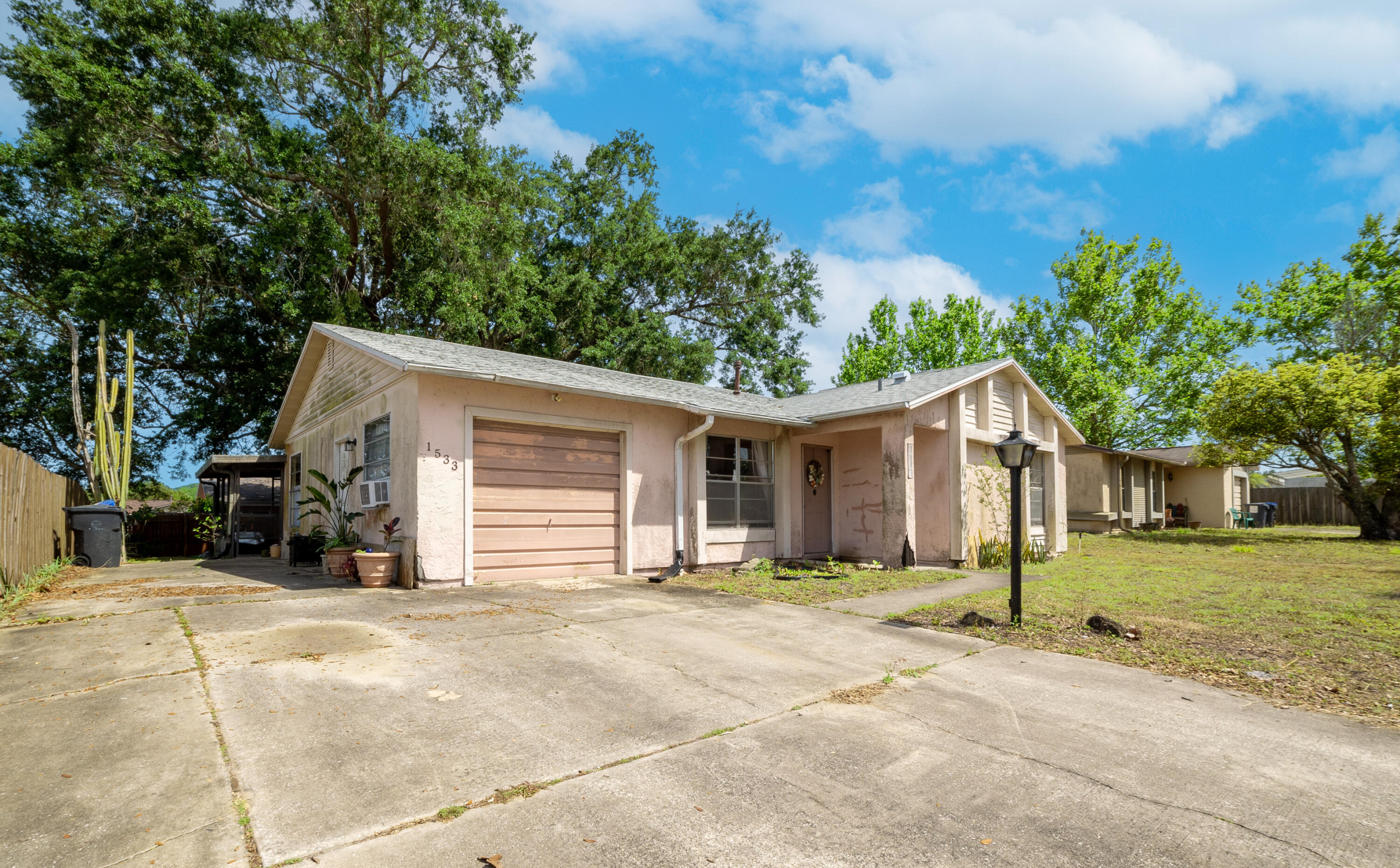 1533 West Powder Horn Road Titusville, FL 32796 - Photo 2 of 29 a view of a house with a yard and garage