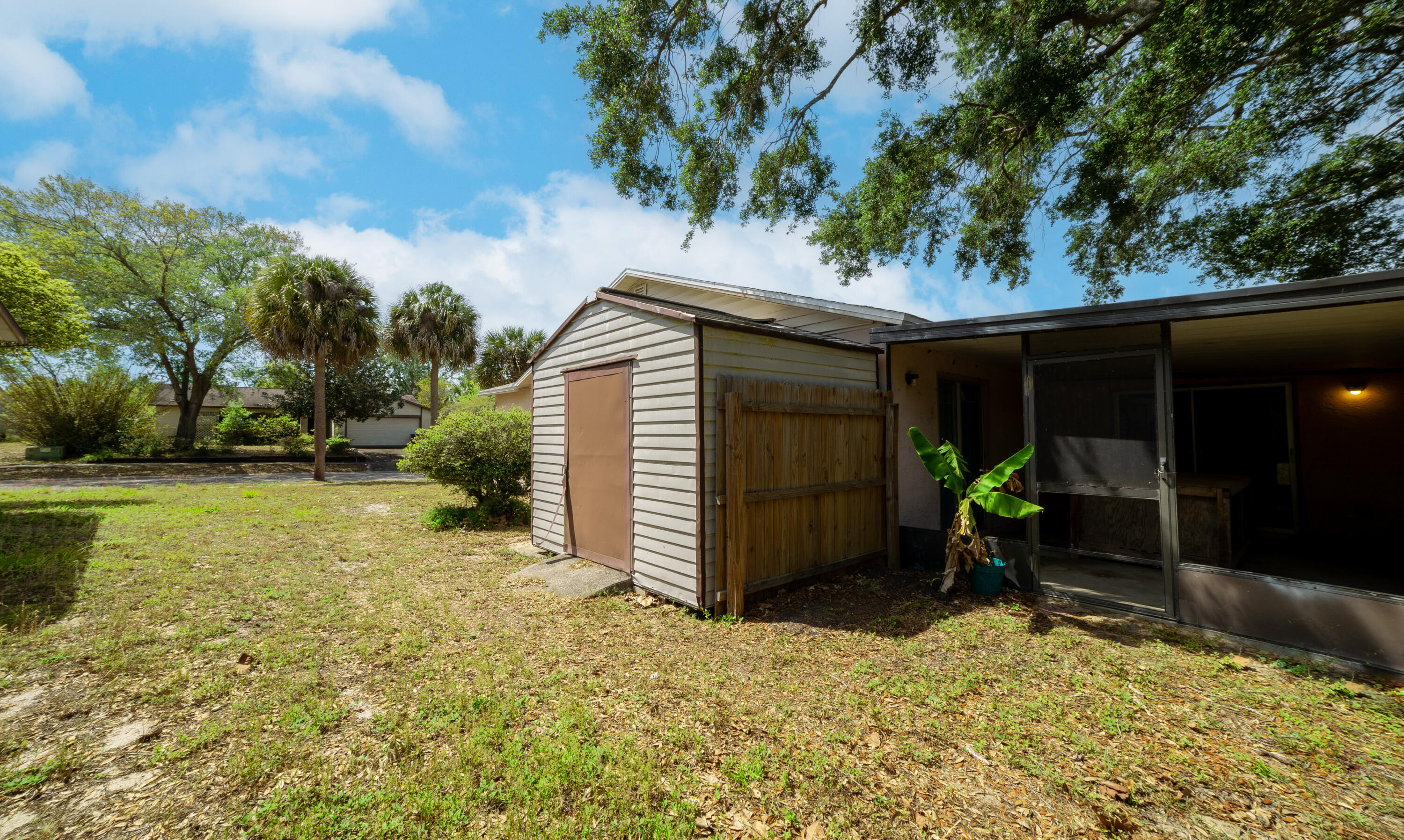 1533 West Powder Horn Road Titusville, FL 32796 - Photo 26 of 29 a backyard of a house with plants and wooden fence