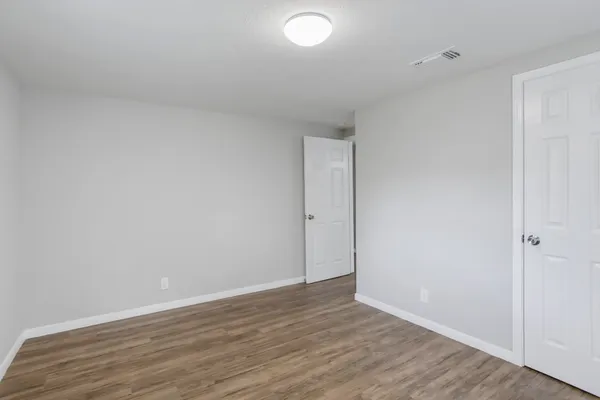 a view of an empty room with wooden floor