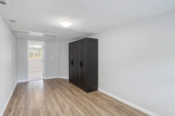 a view of an empty room with closet and a window