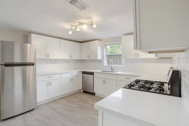 a kitchen with a white appliances a sink and cabinets