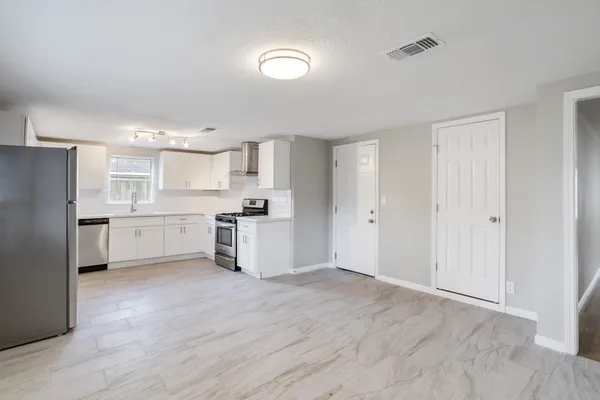 a kitchen with white cabinets and white appliances