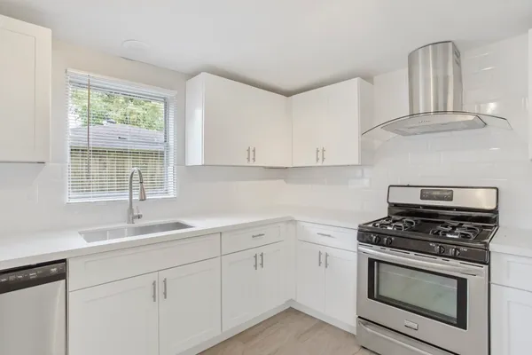 a kitchen with white cabinets stainless steel appliances and sink