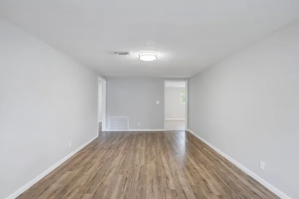 a view of an empty room with wooden floor