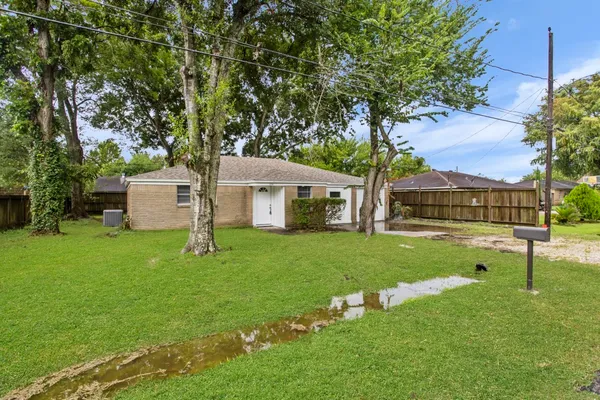 a front view of a house with a yard and tree