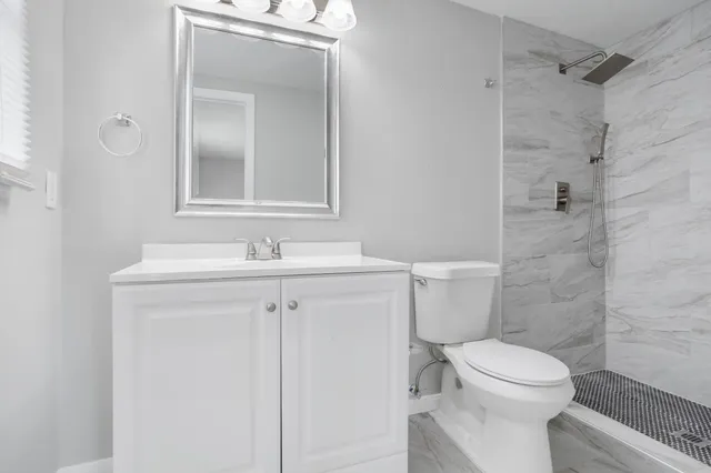 a bathroom with a sink a toilet and shower