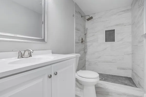 a bathroom with a granite countertop sink toilet and shower