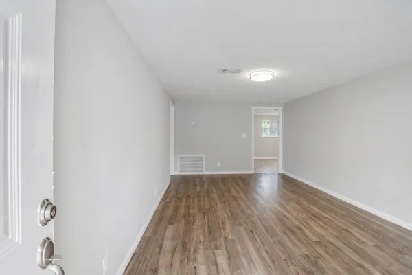 a view of an empty room and wooden floor