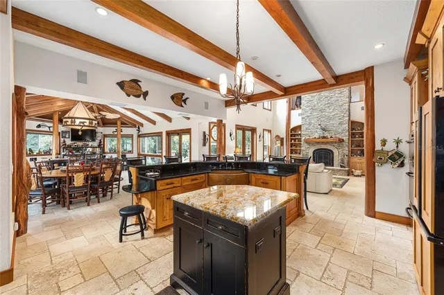 a kitchen with stainless steel appliances granite countertop a refrigerator a stove and white cabinets with wooden floors