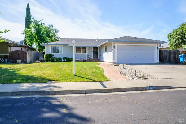 a view of a house with a yard and large tree