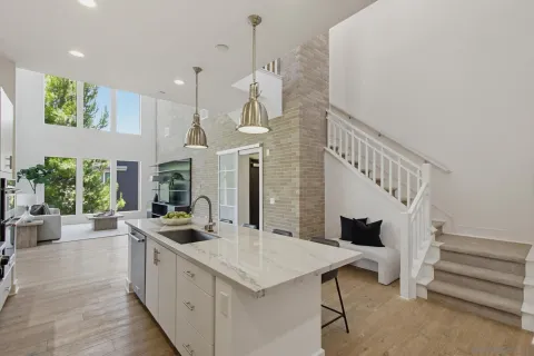 a kitchen with stainless steel appliances kitchen island a table and chairs in it