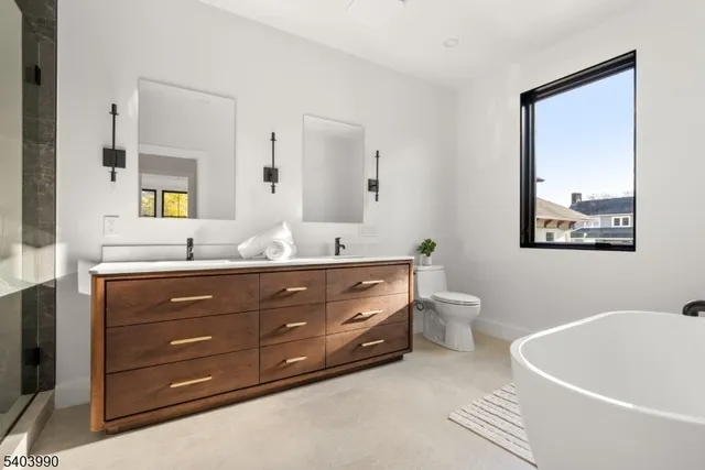 a bathroom with a granite countertop tub a double vanity sink and a large mirror