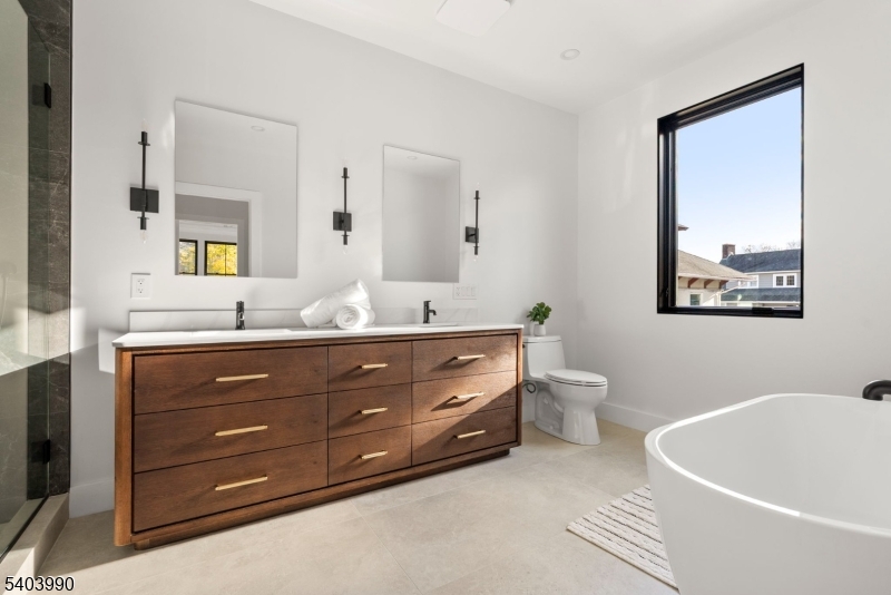 112 Valley Road, Unit B Montclair, NJ 07042 - Photo 6 of 18 a bathroom with a granite countertop tub a double vanity sink and a large mirror