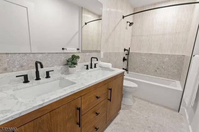 a bathroom with a double vanity sink a mirror and a bathtub