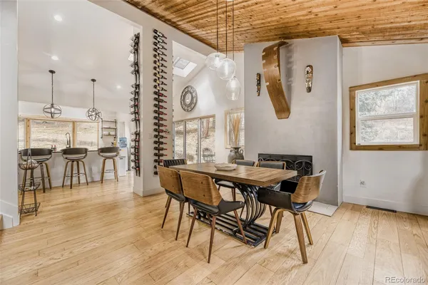 a view of a dining room and livingroom with furniture wooden floor a chandelier