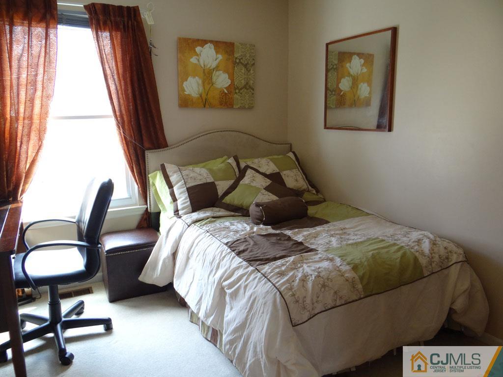 92 Woodbury Road Edison, NJ 08820 - Photo 14 of 16 a bedroom with a bed and a lamp next to a window