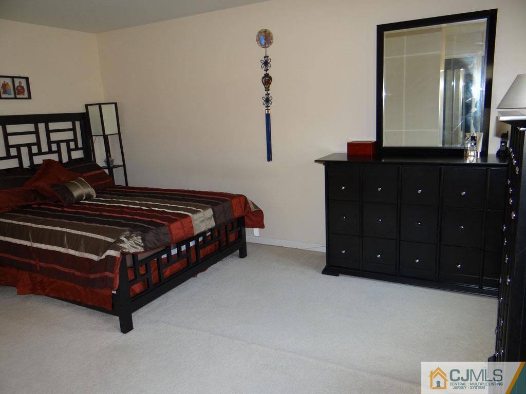 92 Woodbury Road Edison, NJ 08820 - Photo 9 of 16 a bedroom with a bed and a mirror
