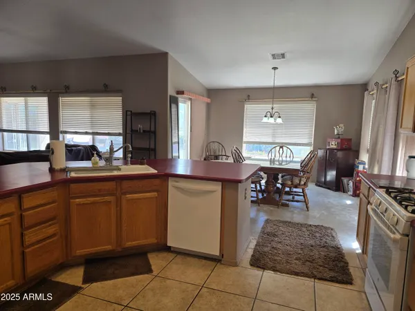 a kitchen with kitchen island granite countertop a sink stove and cabinets