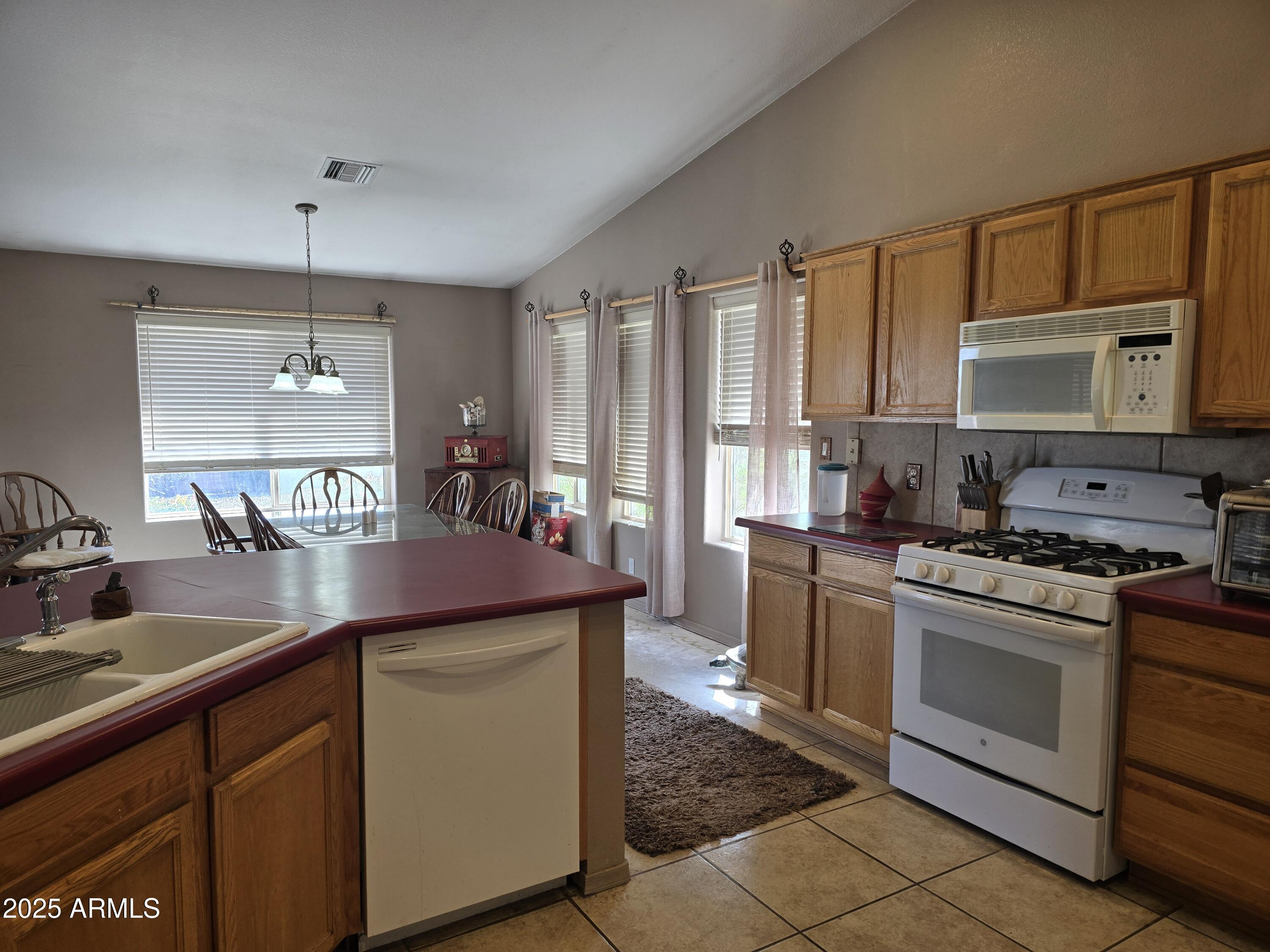 924 West Sahuaro Road Pearce, AZ 85625 - Photo 12 of 32 a kitchen with kitchen island granite countertop a sink stove and cabinets