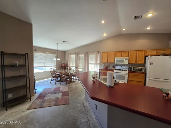 a large living room with stainless steel appliances granite countertop a couch a table and chairs