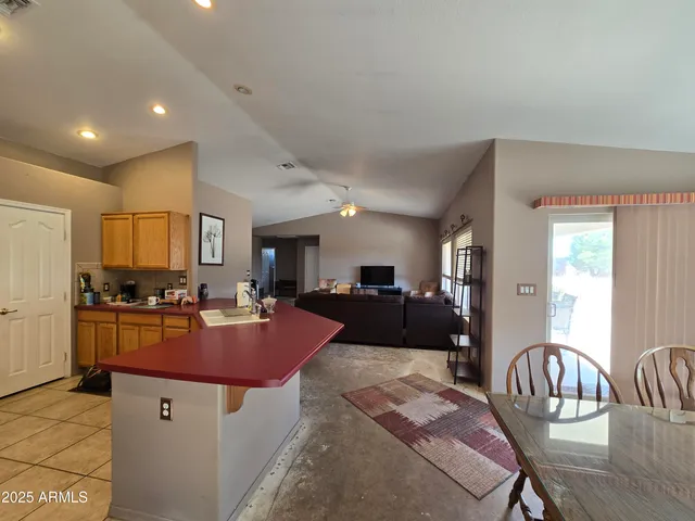 a large kitchen with stainless steel appliances kitchen island granite countertop a refrigerator and a sink