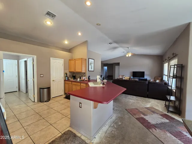 a kitchen with granite countertop a refrigerator stove and sink
