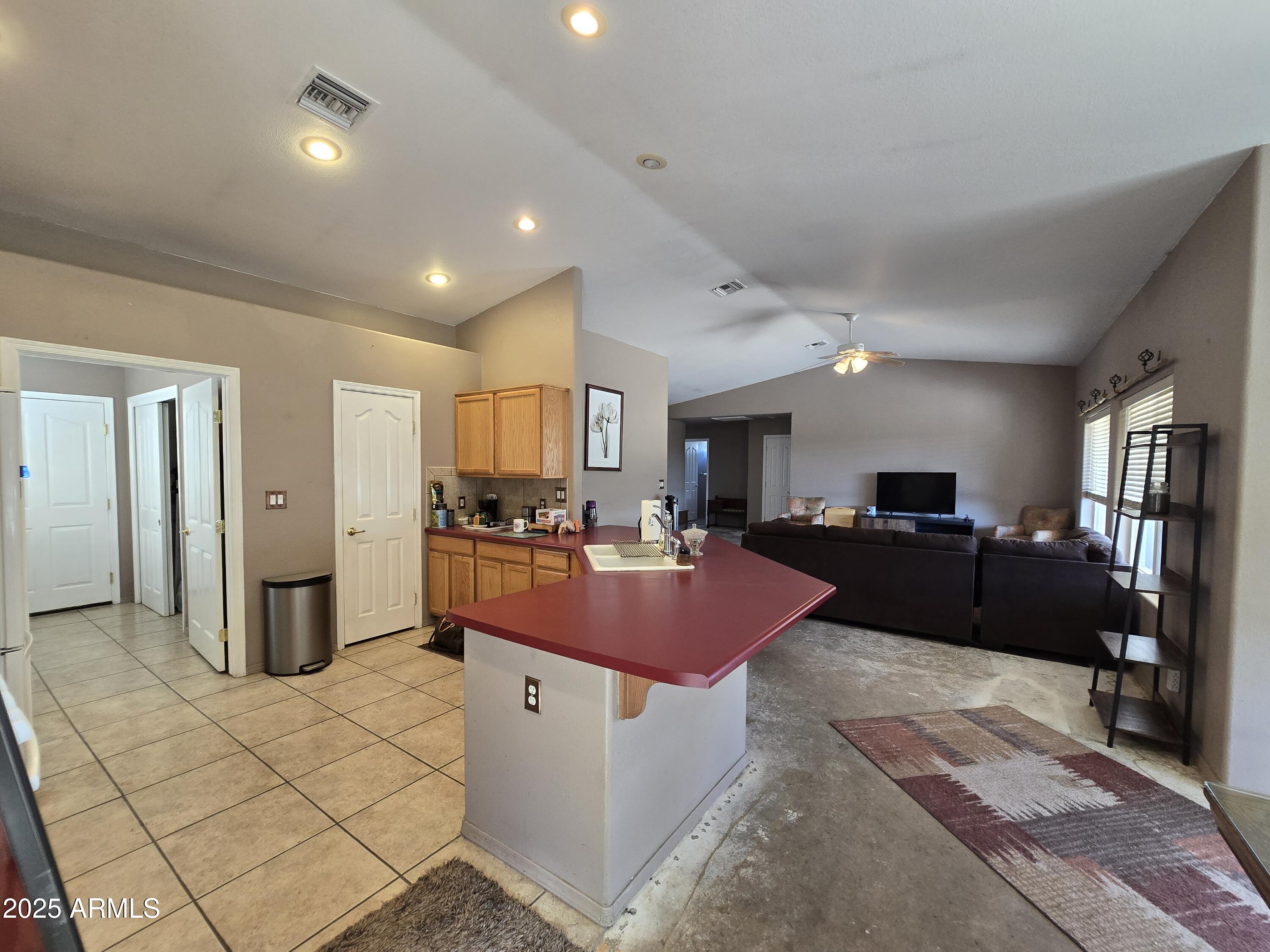 924 West Sahuaro Road Pearce, AZ 85625 - Photo 9 of 32 a large kitchen with stainless steel appliances kitchen island granite countertop a refrigerator and a sink